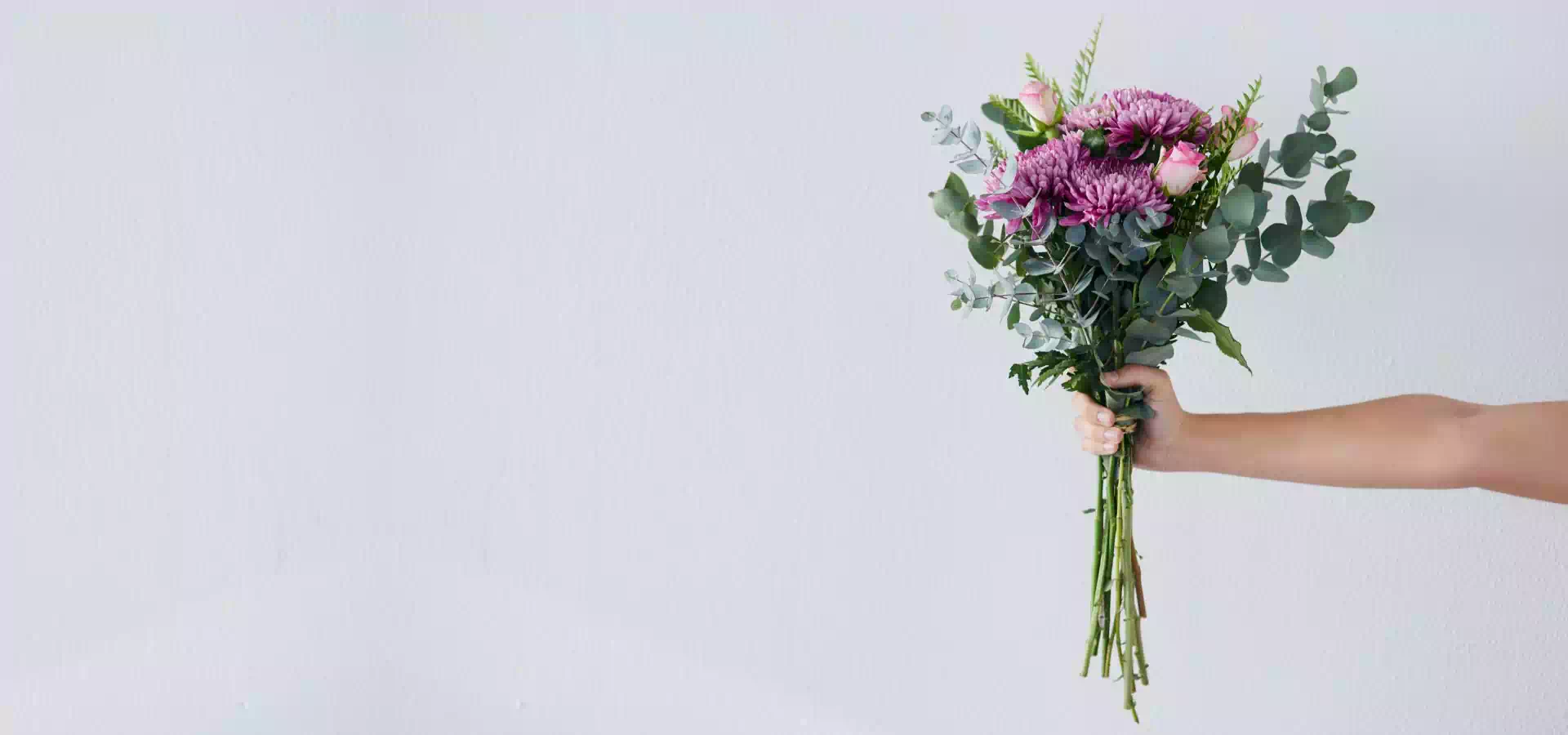 wyciągnięta ręka z bukietem kwiatów